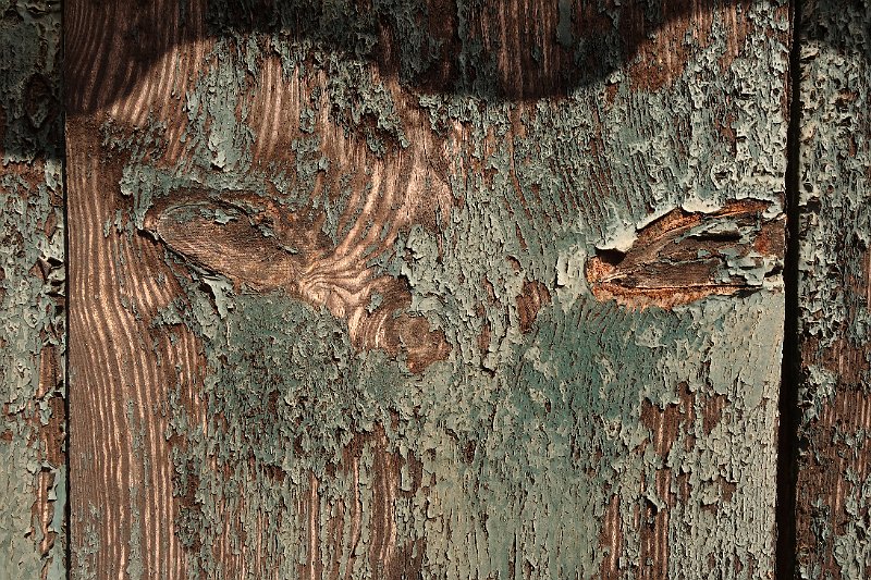 AB02.jpg - Bij deze foto geeft de schaduw aan de bovenkant een versterkend effect op de "ogen" in het hout. Mooi hoe de kleuren van het hout tot leven komen onder de afgebladderde verf. 